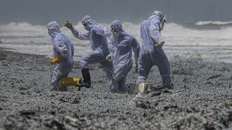 Marines dello Sri Lanka in tute protettive cercano di schivare un'ondata di relitti alla deriva a terra dalla nave in fiamme di Singapore MV X-Press Pearl al largo del porto di Colombo a Kabongoda, Sri Lanka, giovedì 27 maggio 2021. Pic: AP