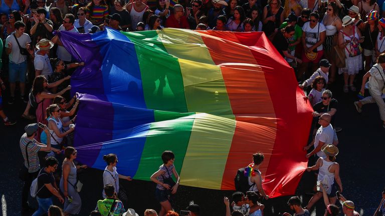 FILE - In this file photo dated Saturday, July 6, 2019, participants of the annual LGBTQ pride parade carry the emblematic rainbow flag in Madrid, Spain. The Spanish Cabinet on Tuesday June 29, 2021, passed a draft bill on LGBTQ rights that will seek parliamentary approval to allow transgender people over 16 years old to freely change their gender and name in the official registry without doctors or witnesses intervening in the process. (AP Photo/Manu Fernandez)
