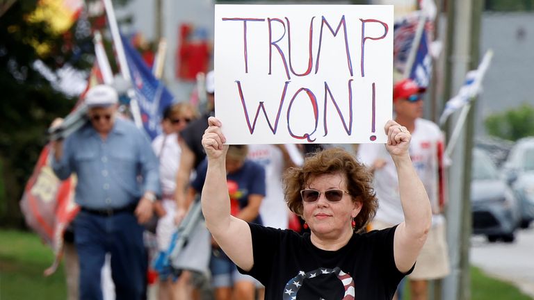 Trump supporters holding placards saying he won elections