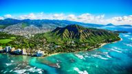 The dormant volcano known as Diamond Head located adjacent to downtown Honlulu, Hawaii, as shot from an altitude of about 1500 feet over the Pacific Ocean.