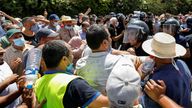 A police officer pushes back supporters of Tunisia&#39;s Ennahdha political party