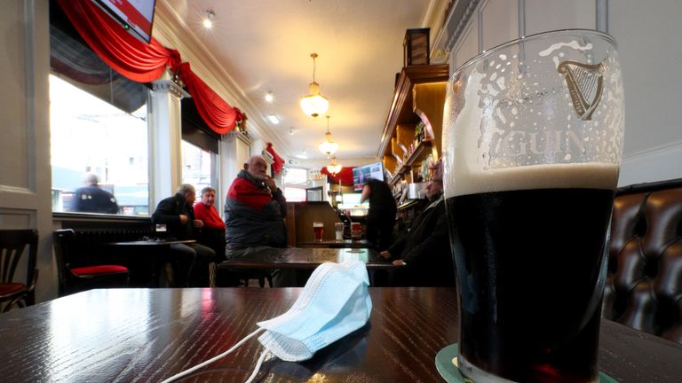 A close up of a pint of Guinness and a face mask on a table in the Richmond pub in Liverpool watch a statement by the Prime Minister Boris Johnson, as parts of the North of England are bracing themselves for the most stringent Tier 3 controls, with Merseyside expected to have its pubs, gyms and casinos closed in a bid to suppress its infection rate.