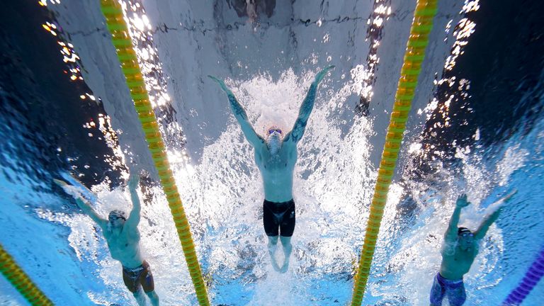 آدام پیتی بریتانیایی، مرکز، برای کسب مدال طلا در فینال 100 متر قورباغه در بازی های المپیک تابستانی 2020، دوشنبه، 26 ژوئیه 2021، در توکیو، شنا می کند.  (AP Photo / دیوید جی فیلیپ)