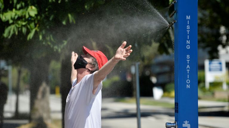 A man cools off at a misting station during the scorching weather of a heatwave in Vancouver, British Columbia, Canada June 27, 2021. REUTERS/Jennifer Gauthier