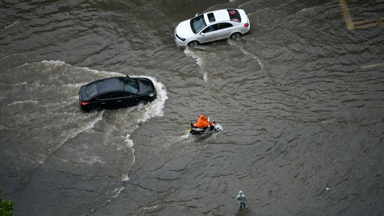 People ride in the waterlogging caused by rainstorm in Zhengzhou city, central China's Henan province, 20 July 2021. (Imaginechina via AP Images)


