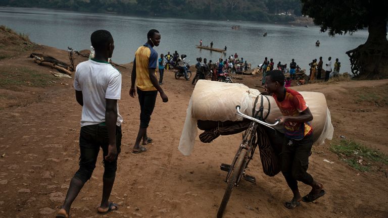  Jeremy Kowomando, 32, and his 14-large family, cross the Mbomou river back into Bangassou, Central African Republic, from   Ndu in the Democratic Republic of the Congo, where they had taken refuge, Sunday Feb. 14, 2021. ...For more than a month we received no aid,... says Kowomando, explaining why he was returning. An estimated 240,000 people have been displaced in the country since mid-December, according to U.N. relief workers, when rebels calling themselves the Coalition of Patriots for Change launched attacks, causing a humanitarian crisis in the already unstable nation. (AP Photo/Adrienne Surprenant)