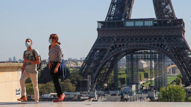 People wearing protective face masks as precaution against the conoravirus walk at Tocadero plaza near Eiffel Tower in Paris, Monday, Sept. 14, 2020. France sees a substantial increase of Covid-19 cases. (AP Photo/Michel Euler)