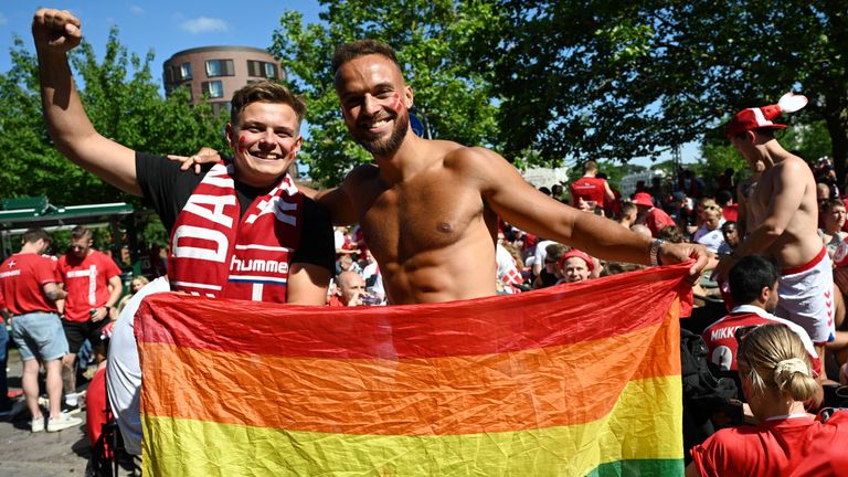 Denmark fans pose in Copenhagen with a rainbow coloured flag before the match