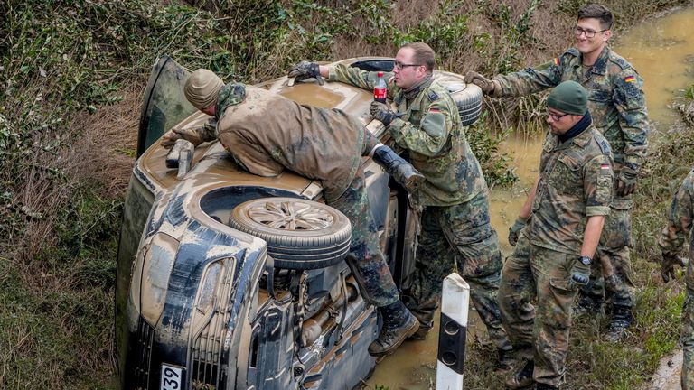 German soldiers work on a flooded car on a road in Erftstadt, Germany, Saturday, July 17, 2021. Due to strong rainfall, the small Erft river went over its banks causing massive damage. (AP Photo/Michael Probst)


