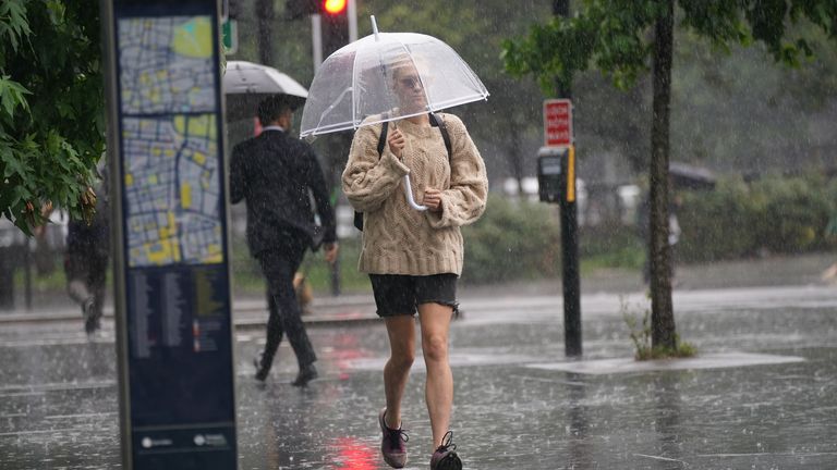 A person walks through a heavy downpour in Euston, London
