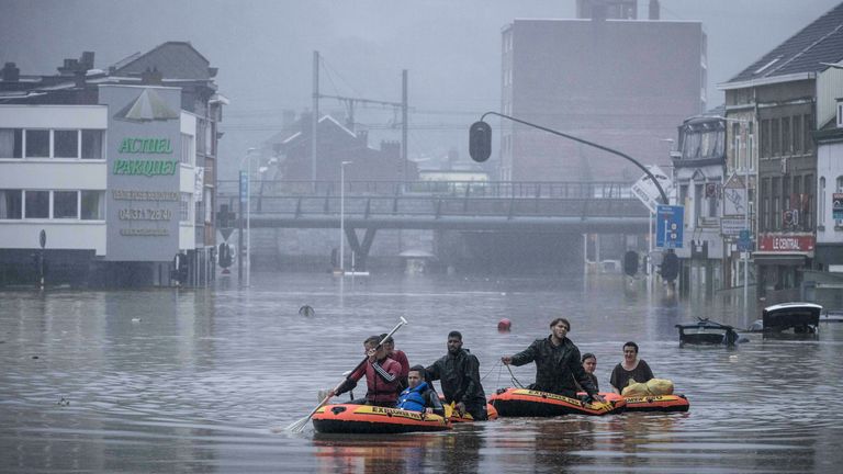 Les gens utilisent des radeaux en caoutchouc dans les eaux de crue après que la Meuse a brisé ses rives lors de fortes inondations à Liège, en Belgique, jeudi