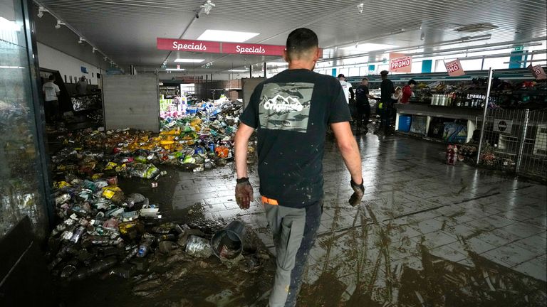 A worker cleans out items from a supermarket after flooding in Pepinster, Belgium, Saturday, July 17, 2021. Residents in several provinces were cleaning up after severe flooding in Germany and Belgium turned streams and streets into raging torrents that swept away cars and caused houses to collapse. (AP Photo/Virginia Mayo)      