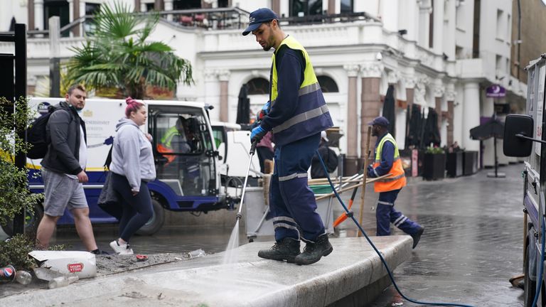 Workers continue to clean Leicester Square at in central London on Monday morning