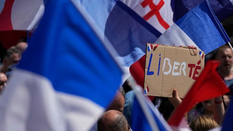 A protestor waves a sign which reads 'freedom' in the middle of French flags during a demonstration in Paris, France, Saturday, July 31, 2021. Demonstrators gathered in several cities in France on Saturday to protest against the COVID-19 pass, which grants vaccinated individuals greater ease of access to venues. (AP Photo/Michel Euler)


