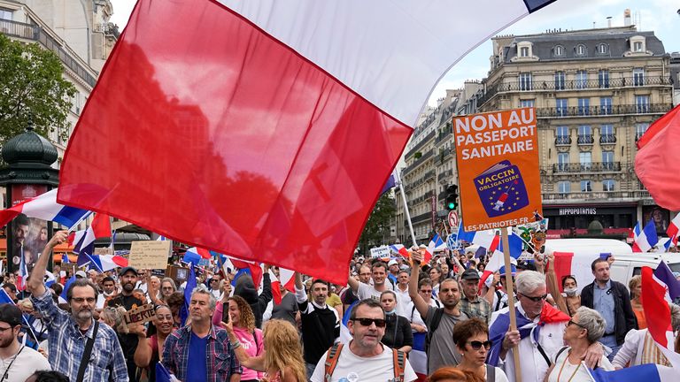 Demonstranten tragen Banner mit französischer Aufschrift, "Freiheit" und & # 39;  Nein zum Impfpass" Während der Teilnahme an einer Demonstration in Paris, Frankreich, Samstag, 31. Juli 2021. Demonstranten versammelten sich am Samstag in mehreren Städten in Frankreich, um gegen die COVID-19-Karte zu protestieren, die geimpften Personen einen besseren Zugang zu Orten ermöglicht.  (Assoziierte Presse/Michael Euler)