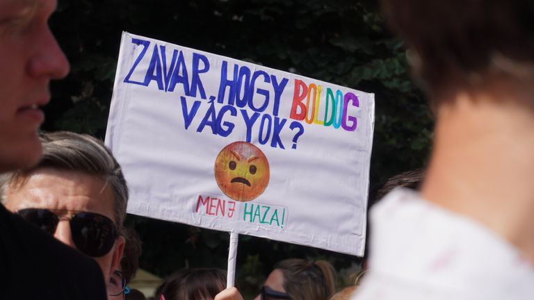 The placard in Hungarian with the emoji reads: “is it bothering you that I’m happy?” It’s in response to a government advertising campaign that features emojis which we mentioned in our report yesterday.       