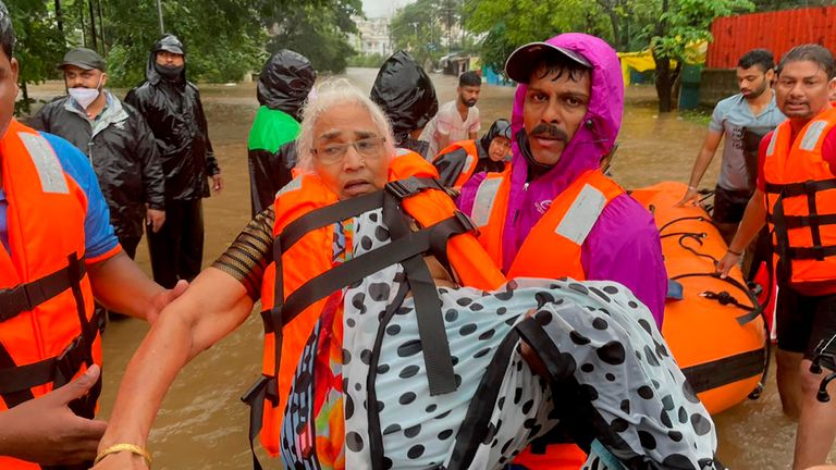 Ein Mitarbeiter der National Disaster Response rettet am Freitag, den 23. Juli 2021, eine ältere Frau, die in Kolhapur im westindischen Bundesstaat Maharashtra in Überschwemmungen gestrandet ist. Durch starke Regenfälle verursachte Erdrutsche haben Teile der Westindischen Inseln getroffen und mindestens 32 Menschen getötet und führte zur Rettung von mehr als 1.000 anderen Menschen, die von Hochwasser eingeschlossen waren, sagten Beamte am Freitag.  (AP-Foto)