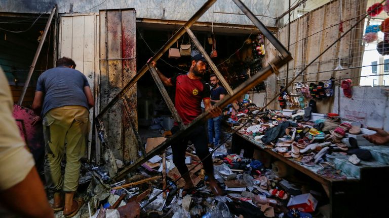 People pick up debris at the site of an explosion in Sadr City district of Baghdad, Iraq July 19, 2021. REUTERS/Wissam Al-Okaili