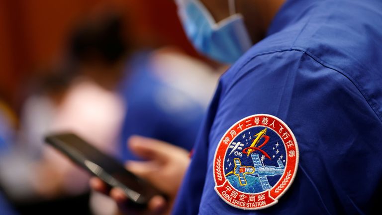 A badge of the Shenzhou-12 Manned Space Flight Mission is seen on the uniform of a staff member of the Jiuquan Satellite Launch Center during a news conference before the Shenzhou-12 mission to build China&#39;s space station, at Jiuquan Satellite Launch Center in Gansu province, China June 16, 2021. REUTERS/Carlos Garcia Rawlins