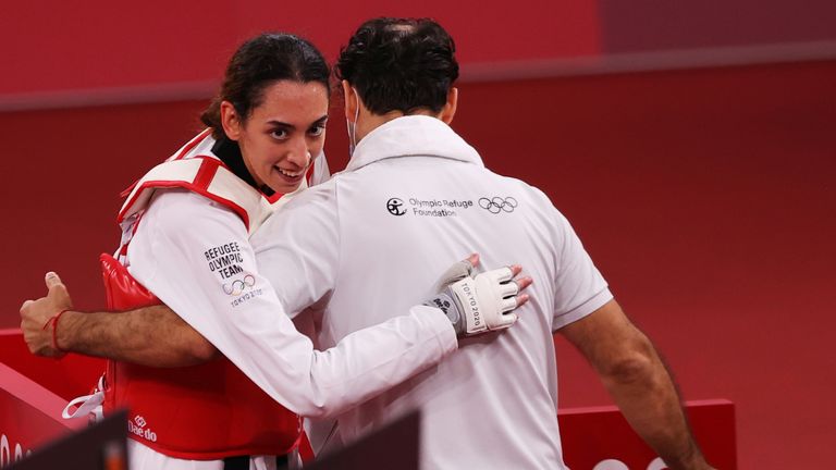 Alizadeh smiles as she hugs her coach after beating the defending champion