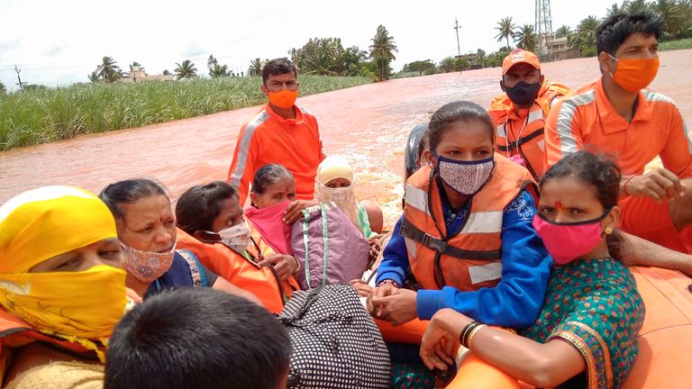 Cette photographie fournie par la Force nationale indienne d'intervention en cas de catastrophe (NDRF) montre le personnel de la NDRF sauvant des femmes et des enfants touchés par les inondations à Kolhapur, dans l'État indien du Maharashtra, dans l'ouest de l'Inde, le dimanche 25 juillet 2021. Des responsables affirment que des glissements de terrain et des inondations provoqués par de fortes pluies de mousson ont fait plus de 100 personnes dans l'ouest de l'Inde.  (Force nationale d'intervention en cas de catastrophe via AP)