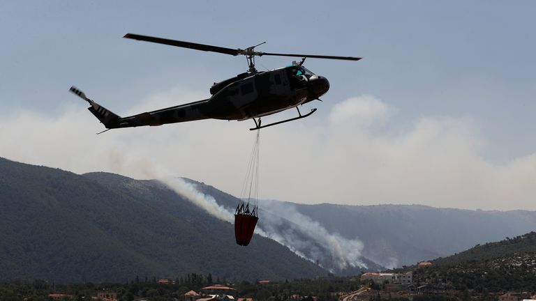 A Lebanese army helicopter takes off from a water storage point after it refilled a tank to extinguish a forest fire, at Qobayat village, in the northern Akkar province, Lebanon, Thursday, July 29, 2021. Lebanese firefighters are struggling for the second day to contain wildfires in the country&#39;s north that have spread across the border into Syria, civil defense officials in both countries said Thursday. (AP Photo/Hussein Malla)


