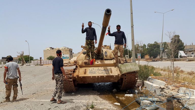 Members of the Libyan pro-government forces gesture as they stand on a tank in Benghazi, Libya, 21 May, 2015