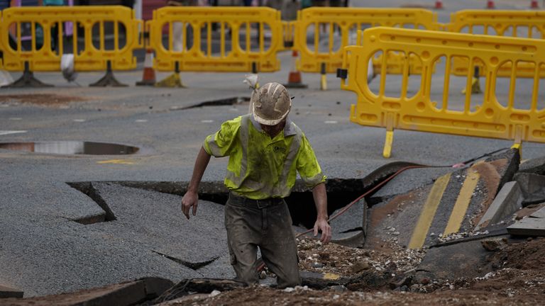 A United Utilities worker inspects a 4.5 metre (15ft) by six metre (20ft) sinkhole in Green Lane, Old Swan, Liverpool, caused by a suspected ruptured water main. Picture date: Saturday July 24, 2021.
