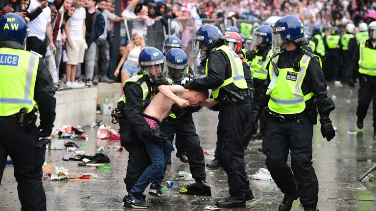 Metropolitan police officers detain a man in front of the National Gallery, in Trafalgar Square, London during the UEFA Euro 2020 Final between Italy and England. Picture date: Sunday July 11, 2021.