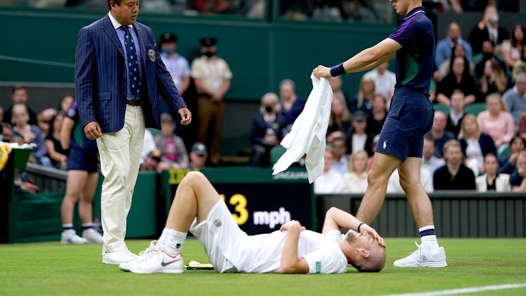 Adrian Mannarino se resbala en el césped durante la primera ronda del partido individual masculino contra Roger Federer en la cancha central en el segundo día en Wimbledon, el All England Lawn Tennis y Crocket Club en Wimbledon.  Imagen Fecha: Martes 29 de junio de 2021.