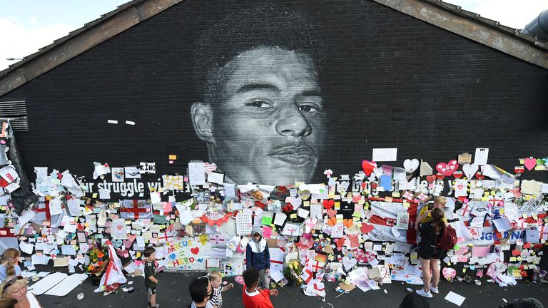 Soccer Football - Stand Up to Racism Demonstration at the Marcus Rashford mural after it was defaced following the Euro 2020 Final between Italy and England - Withington, Manchester, Britain - July 13, 2021 People look at messages of support on the Marcus Rashford mural after it was defaced following the Euro 2020 Final between Italy and England REUTERS/Peter Powell