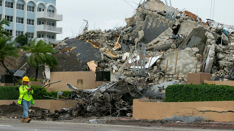 A workers make her way past the rubble and debris of the Champlain Towers South condo in Surfside, Florida on Tuesday, July 6, 2021. The rubble shown here is from the front portion of the condo towers, which was demolished 11 days after the back part of the tower collapsed with people inside.