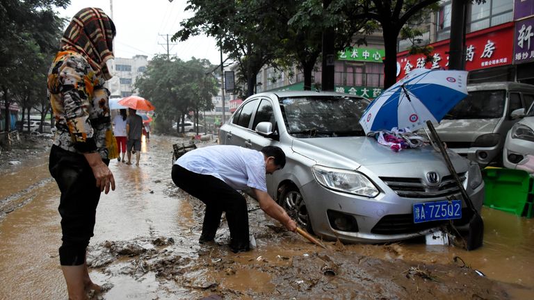 Residents clean up the aftermath of a flood in Mihe Town of Gongyi City