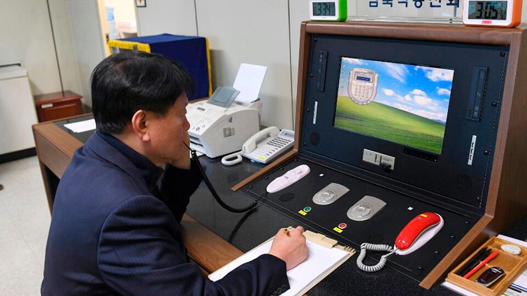 A South Korean government official communicates with a North Korean officer during a phone call on the communications hotline at the border village of Panmunjom (file image)