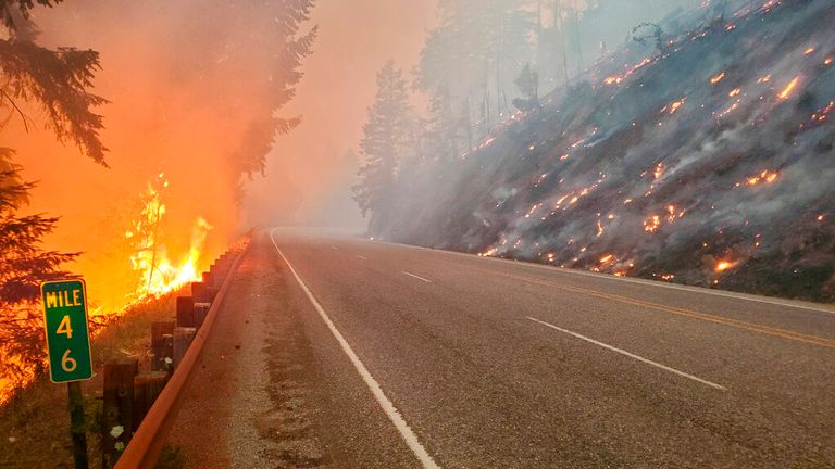 Flames from the Jack Fire burn along a road in Oregon