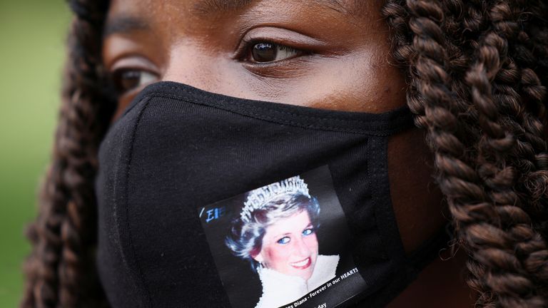 A woman wears a face mask with a picture of Britain's Princess Diana, outside Kensington Palace in London, Britain, June 30, 2021. REUTERS/Henry Nicholls