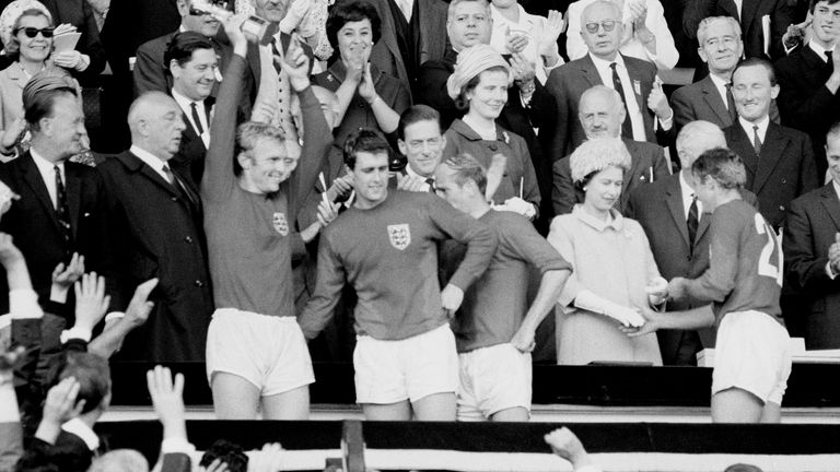 England&#39;s 1966 World Cup heroes celebrate with the trophy after it was presented to them by the Queen