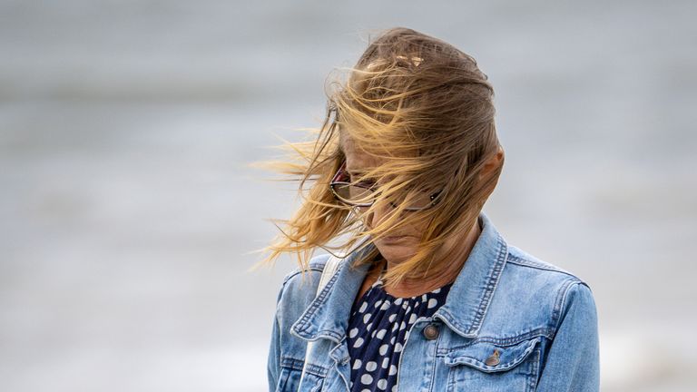 Les cheveux d'une femme sont soufflés sur le côté alors qu'elle se promène le long du front de mer à Porthcawl, au Pays de Galles, après que des vents allant jusqu'à 75 mph ont frappé certaines parties du sud-ouest alors que la tempête Evert a frappé le Royaume-Uni jeudi et vendredi.  Le Met Office a déclaré que la tempête nouvellement nommée apportera "des vents anormalement forts et de fortes pluies".  Date de la photo : vendredi 30 juillet 2021.
