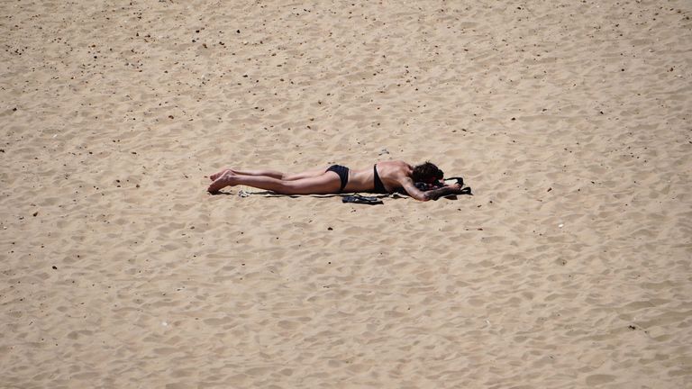 A woman sunbathing on Bournemouth beach in Dorset. England could see the hottest day of the year this weekend as the skies finally clear after weeks of wet and humid weather. Picture date: Saturday July 17, 2021.

