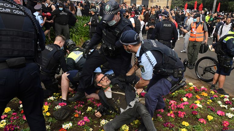 Police officers detain protesters during an anti-lockdown rally as an outbreak of the coronavirus disease (COVID-19) affects Sydney, Australia, July 24, 2021. AAP Image/Mick Tsikas via REUTERS ATTENTION EDITORS - THIS IMAGE WAS PROVIDED BY A THIRD PARTY. NO RESALES. NO ARCHIVE. AUSTRALIA OUT. NEW ZEALAND OUT