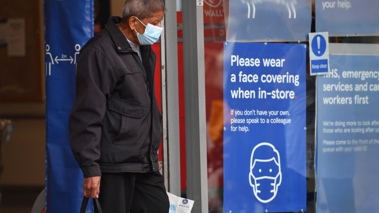 A shopper wearing a face mask leaves Tesco in Leicester city centre as non-essential shops in the city reopen following a local lockdown and face coverings become mandatory in shops and supermarkets in England.