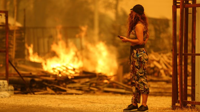 A resident watches the flames in an area scorched by a forest fire near the town of Manavgat, east of the resort city of Antalya, Turkey, July 29, 2021. REUTERS/Kaan Soyturk
