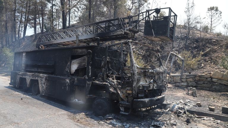 Un camion dei vigili del fuoco in fiamme è visto in un'area bruciata da un incendio boschivo vicino alla città di Manavgat, a est della città turistica di Antalya, in Turchia, 29 luglio 2021. REUTERS/KAN SWITURK