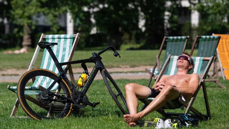 A man sunbathes in Green Park, central London