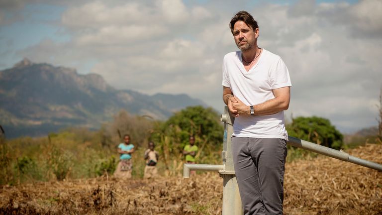 L'ambassadeur de WaterAid, Dougray Scott, se tient près de la pompe à eau du village de M'Mele, dans le district de Cuamba, dans la province de Niassa, au Mozambique, en mai 2017. Photo : WaterAid/ Eliza Powell