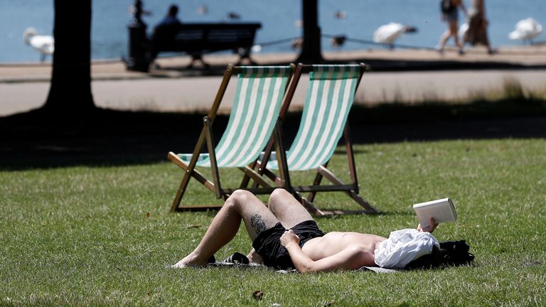 A man relaxes in the warm weather in Hyde Park, London, Britain, July 16, 2021. REUTERS/Peter Nicholls