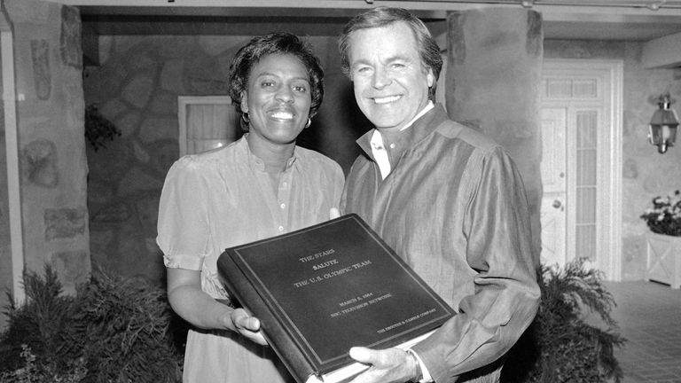 On behalf of the U.S. Olympic Committee Tyus accepts a memorial autograph book from actor Robert Wagner signed by more than 100 stars who were on a TV special in 1984