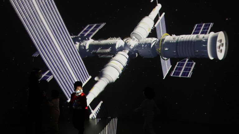 A child stands near a giant screen showing the images of the Tianhe space station at an exhibition featuring the development of China&#39;s space exploration on the country&#39;s Space Day at China Science and Technology Museum in Beijing, China April 24, 2021