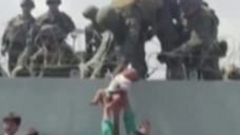 Footage from outside Kabul airport shows an infant being passed over razor wire to soldiers on top of barricades.  