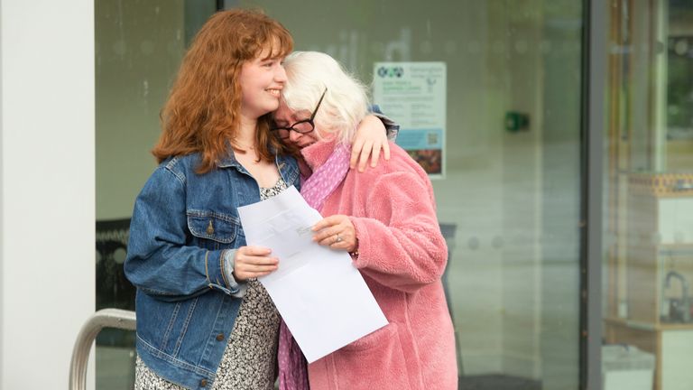 An emotional student hugs her mother at a school in London